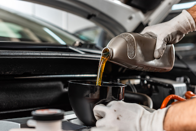 mechanic pouring motor oil into car during oil change service