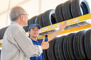 customer and mechanic looking at new car tires