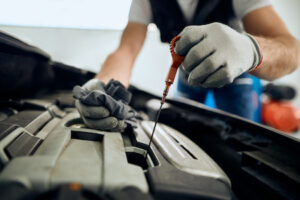 closeup of car mechanic checking motor oil levels